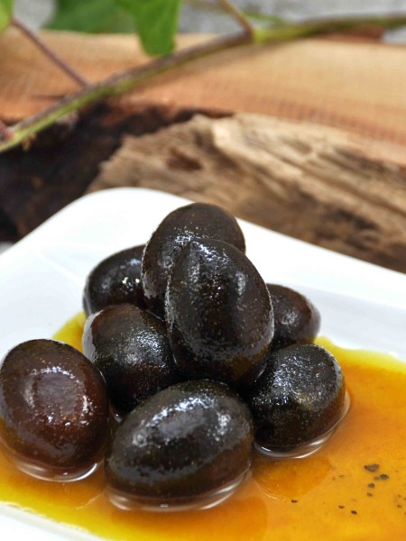 Schwarze Bio Oliven mit Stein in Olivenöl mit Kurkuma und Pfeffer